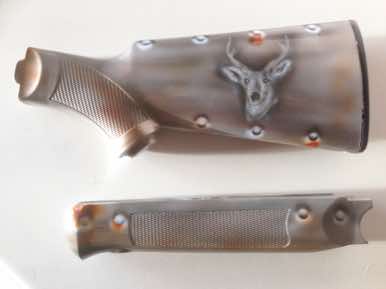 Wooden stock and forend airbrushed like sheet steal and an impressed Stags head
